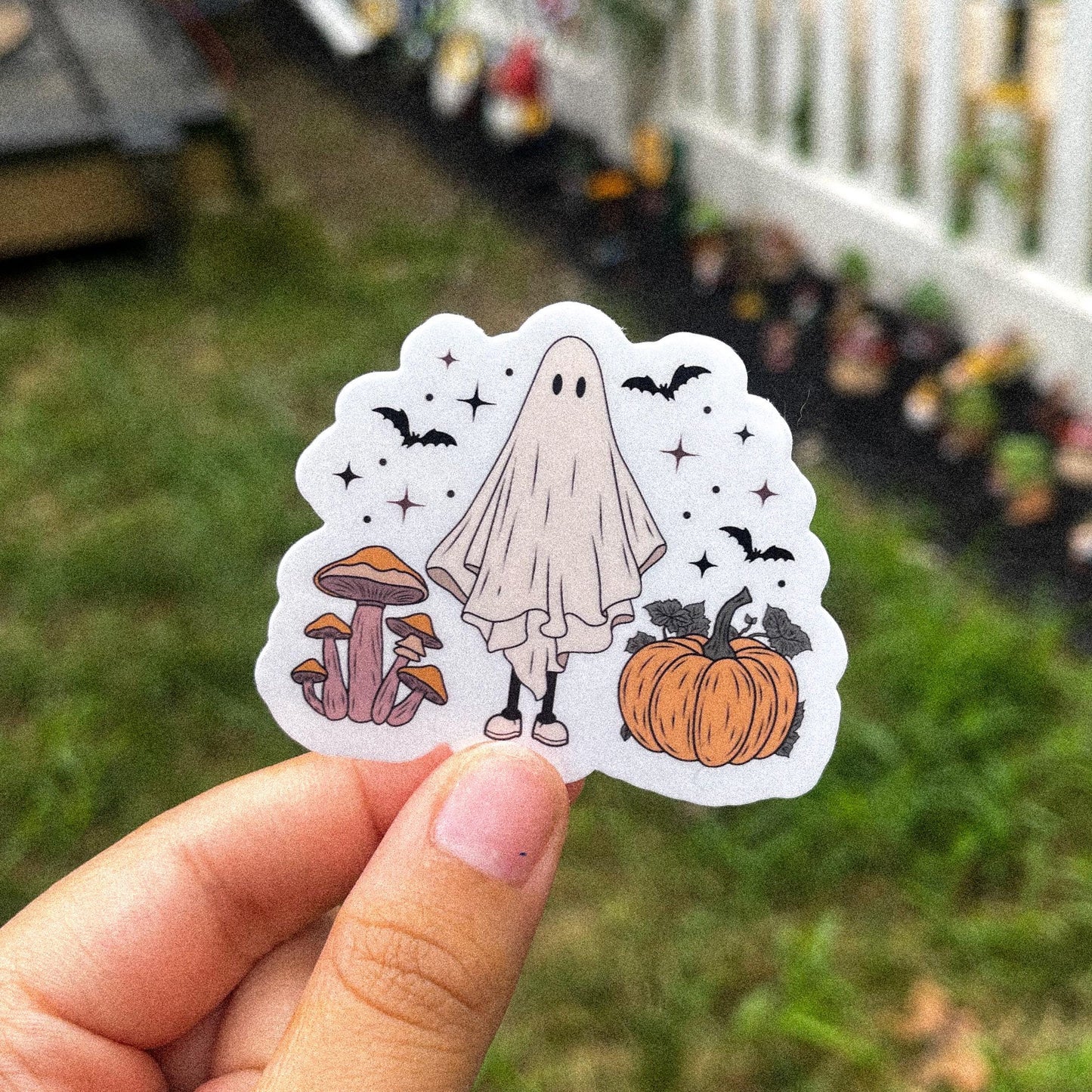 Cozy aesthetic sticker of a ghost surrounded by mushrooms, pumpkins, and bats.