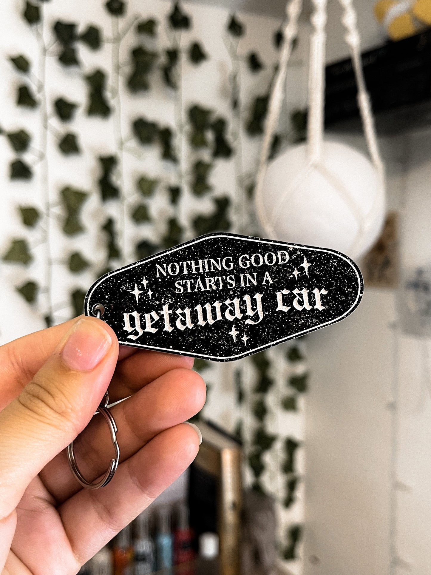 black, sparkly motel keychain with the lyrics "nothing good starts in a getaway car" inspired by taylor swift's album reputation.