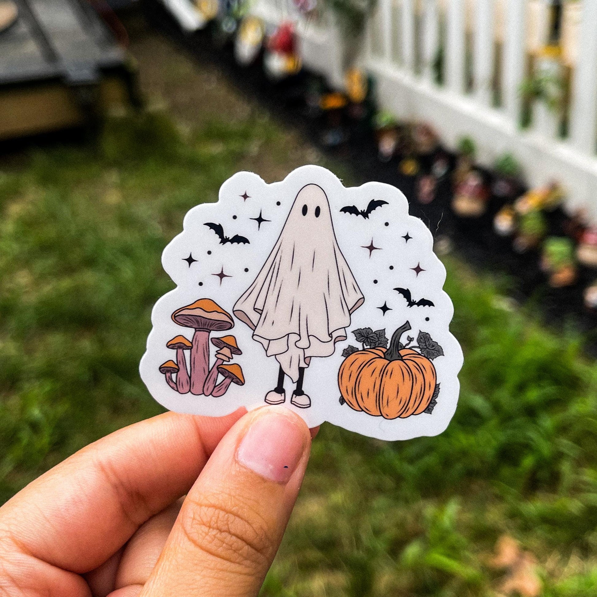 Cozy aesthetic sticker of a ghost surrounded by mushrooms, pumpkins, and bats. 